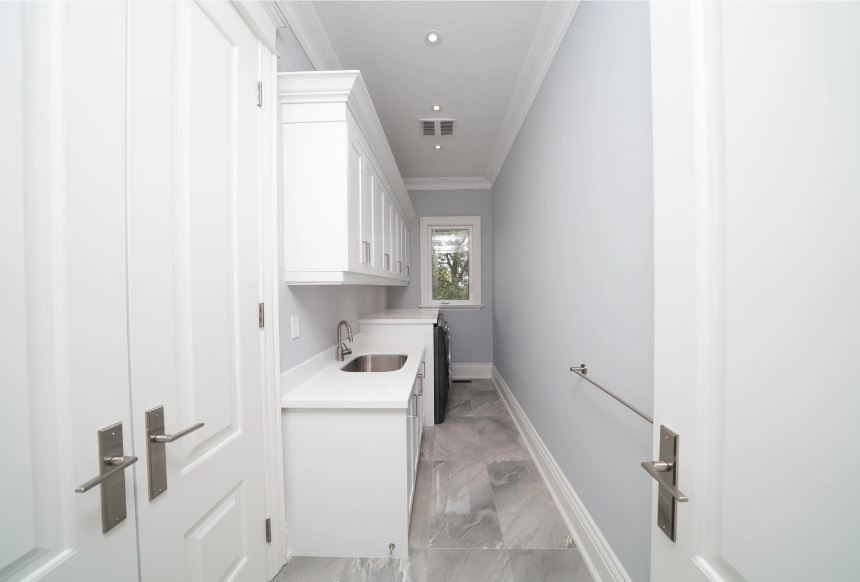 Narrow Space Laundry Room With All White Cabinetry